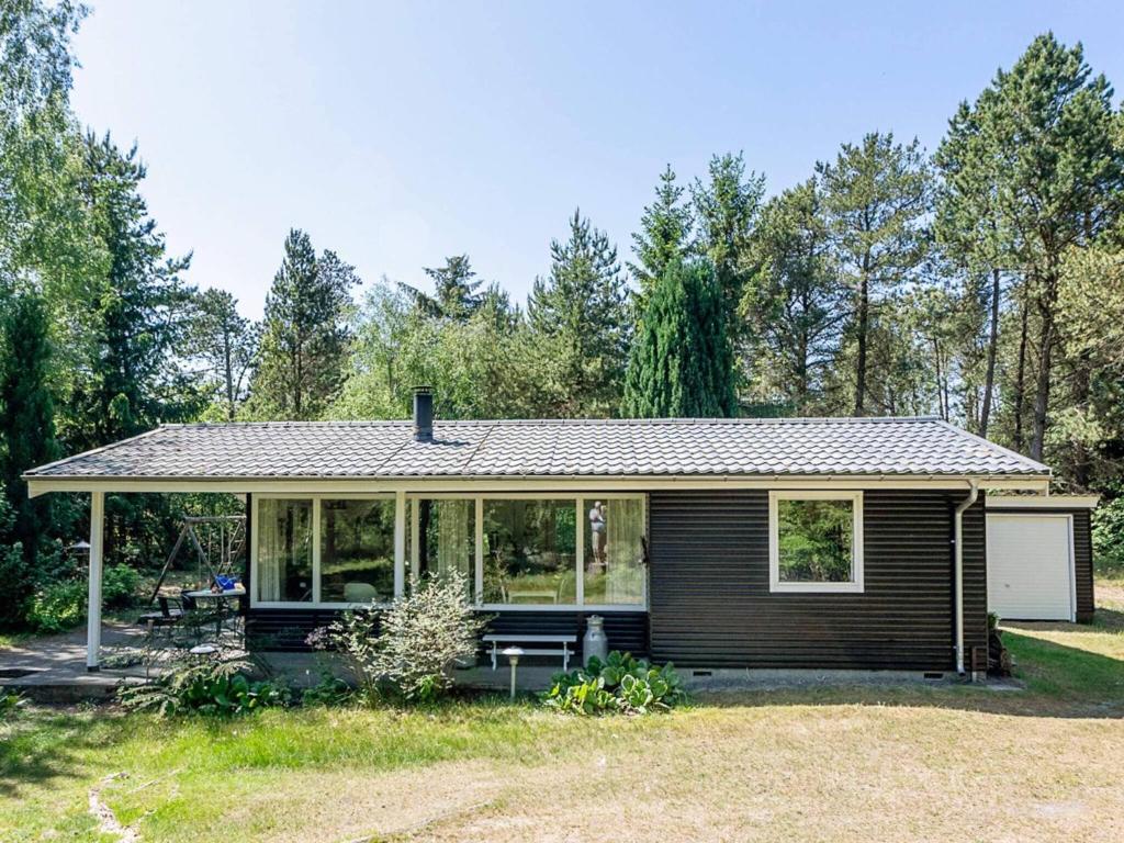 una pequeña casa con un porche cubierto en 5 person holiday home in H jslev, en Sundstrup