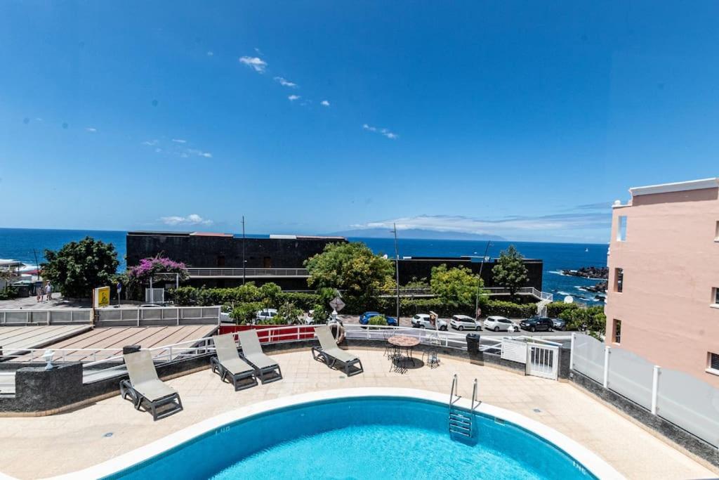 uma piscina com cadeiras e um edifício em Bright 2B Apt 5min from beach by Dream Homes Tenerife em Puerto de Santiago