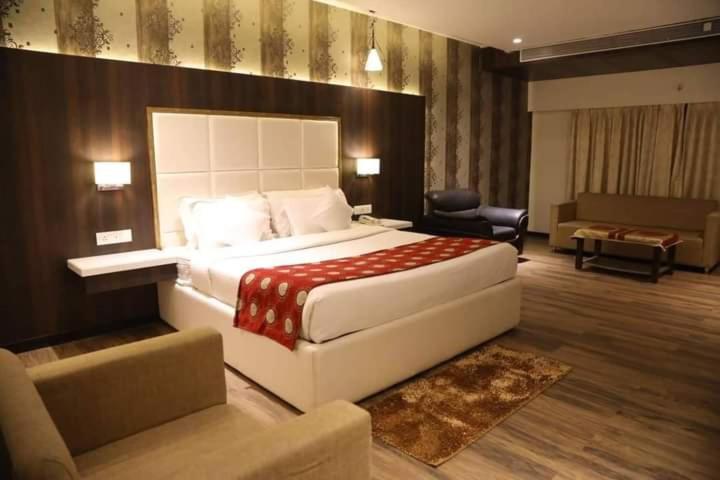 a hotel room with a large bed and a couch at The Four Seasons Recreation in Jālgaon
