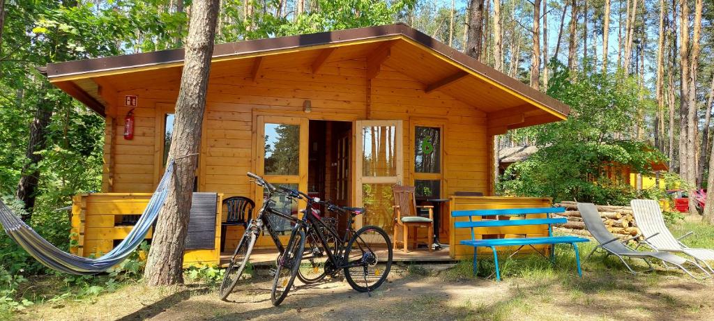 a wooden cabin with a bike parked in front of it at Ośrodek Wypoczynkowy Nad Brdą in Tuchola