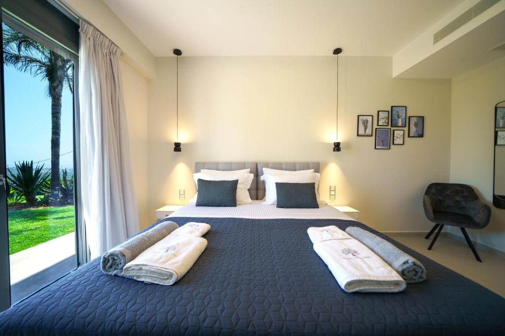 A bed or beds in a room at Mythic Olive villa - Heated Pool - Amazing view