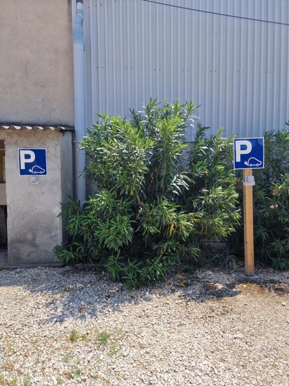 a parking sign sitting in front of a bush at Mas Saint Julien in Cavaillon