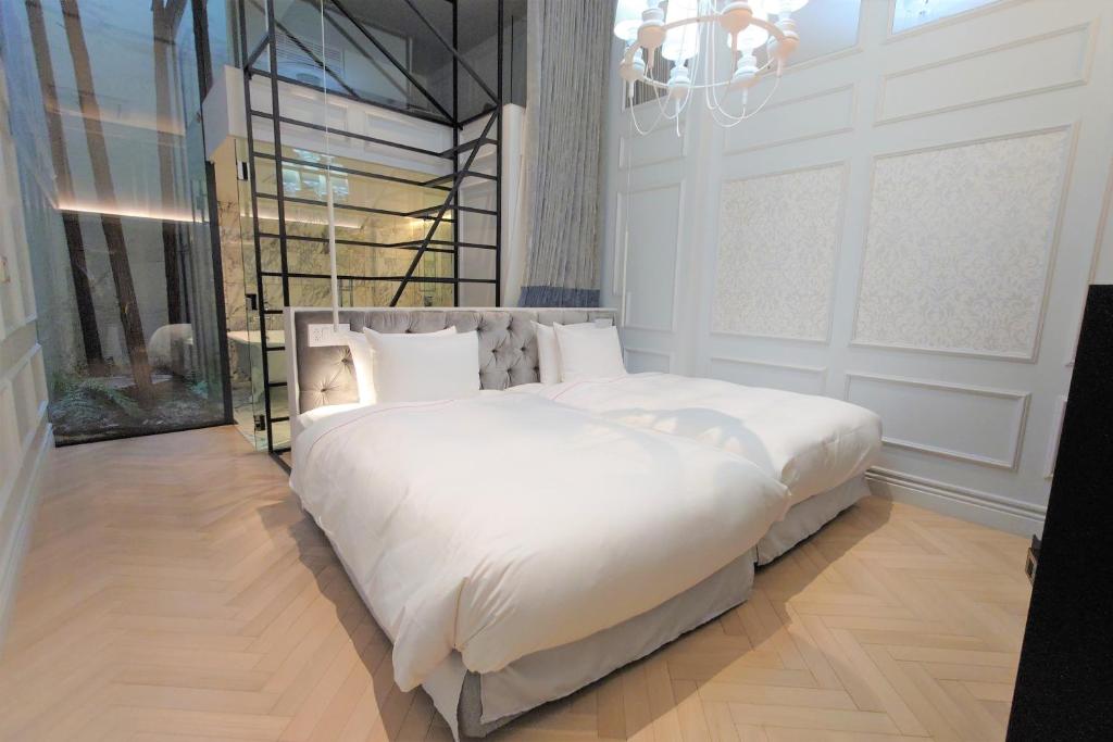a bedroom with a large white bed with a chandelier at A10 hotel azabu ten in Tokyo