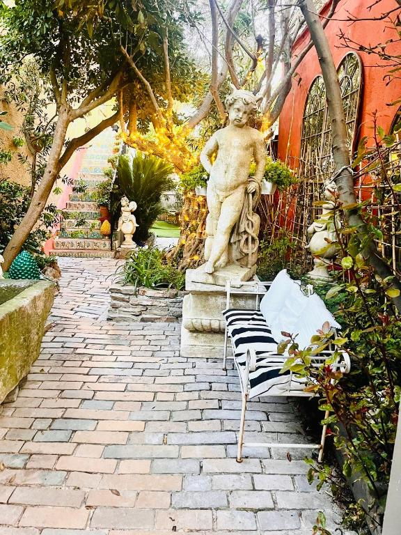 a stone walkway with a statue and a bench at la Romana Luxe et sérénité au cœur de Saint-Tropez Suites spacieuses avec jardin enchanteur in Saint-Tropez