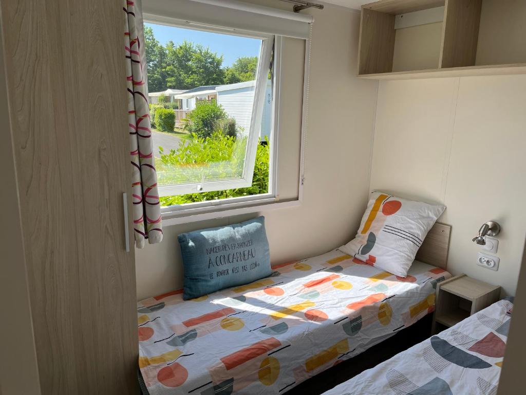 a small bedroom with a bed and a window at MH VAL&amp;YVAN plage, piscine pointe de Trévignon et concarneau in Trégunc