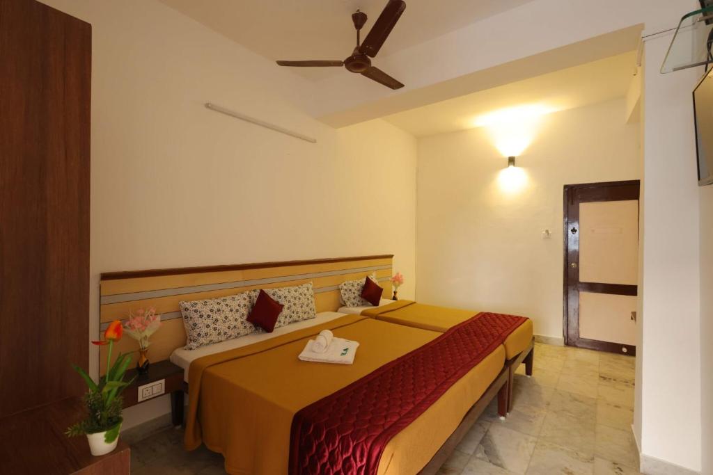 een slaapkamer met een bed en een bank bij VKG Hotels in Pondicherry