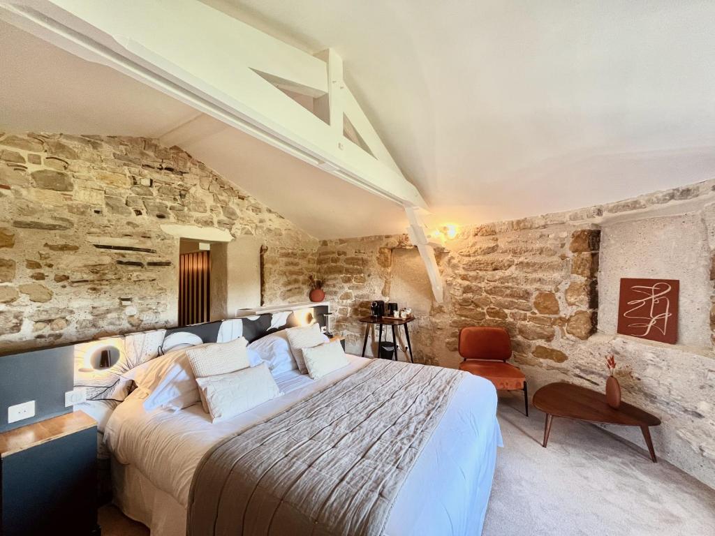 バイヨンヌにあるオテル デ バｰス ピレネー バイヨンヌの石壁のベッドルーム1室(大型ベッド1台付)