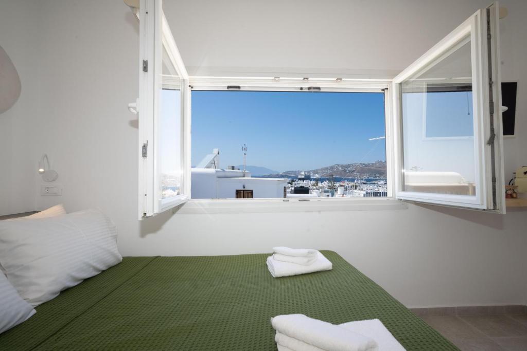 a white room with a large window and a green rug at Salvatore's Island House in Mýkonos City