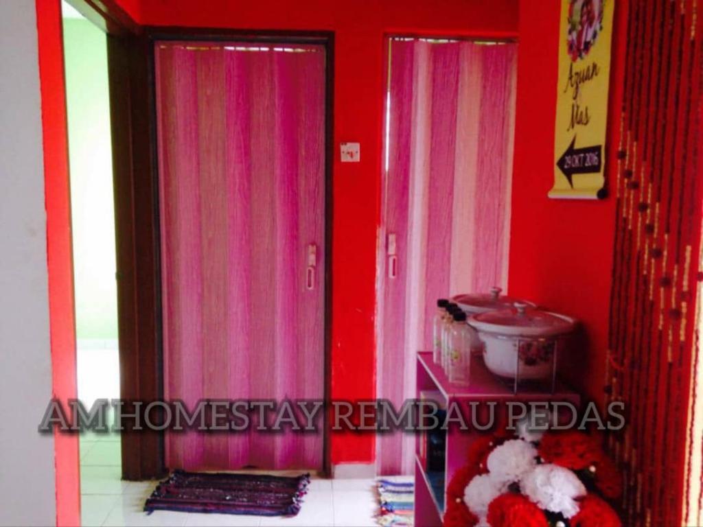 a room with pink curtains and a red wall at Am Homestay Rembau in Rembau