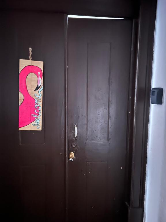 a black door with a picture of a woman on it at Casa Flamingo in Figueira da Foz