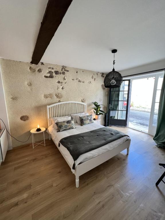 a bedroom with a bed and a large window at Studio - Les Traversières in Eymet