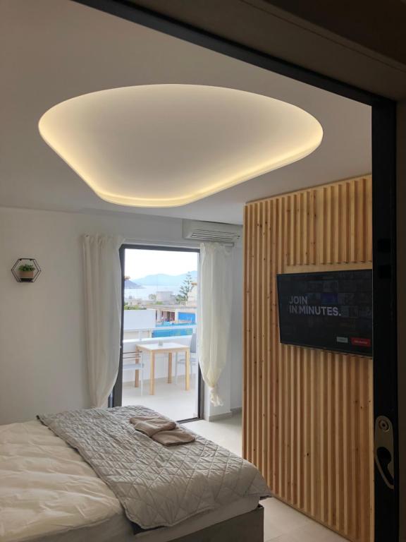 ein Schlafzimmer mit einem Bett und einer großen Decke in der Unterkunft Serafina suite byArtistUnknown in Vari
