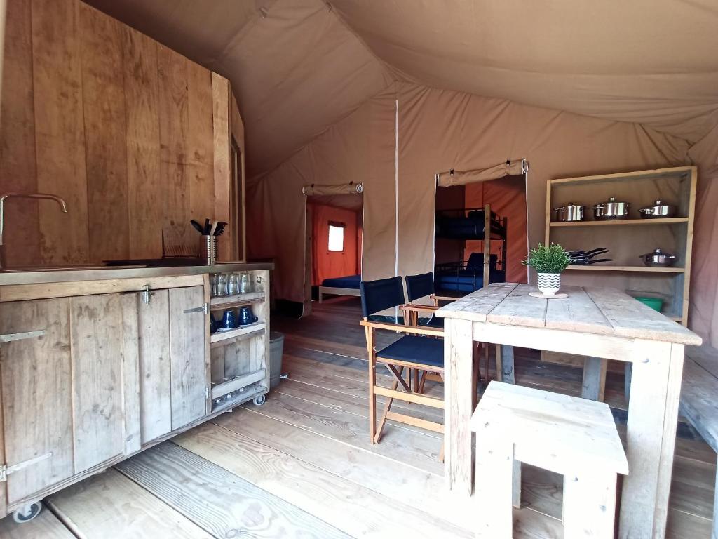 um quarto numa tenda com uma mesa e cadeiras em Le Lodge de la Chouette em Quarré-les-Tombes