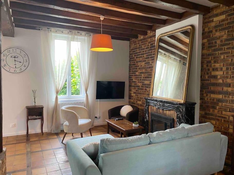 a living room with a couch and a fireplace at La maison du Mineroy in Champignelles