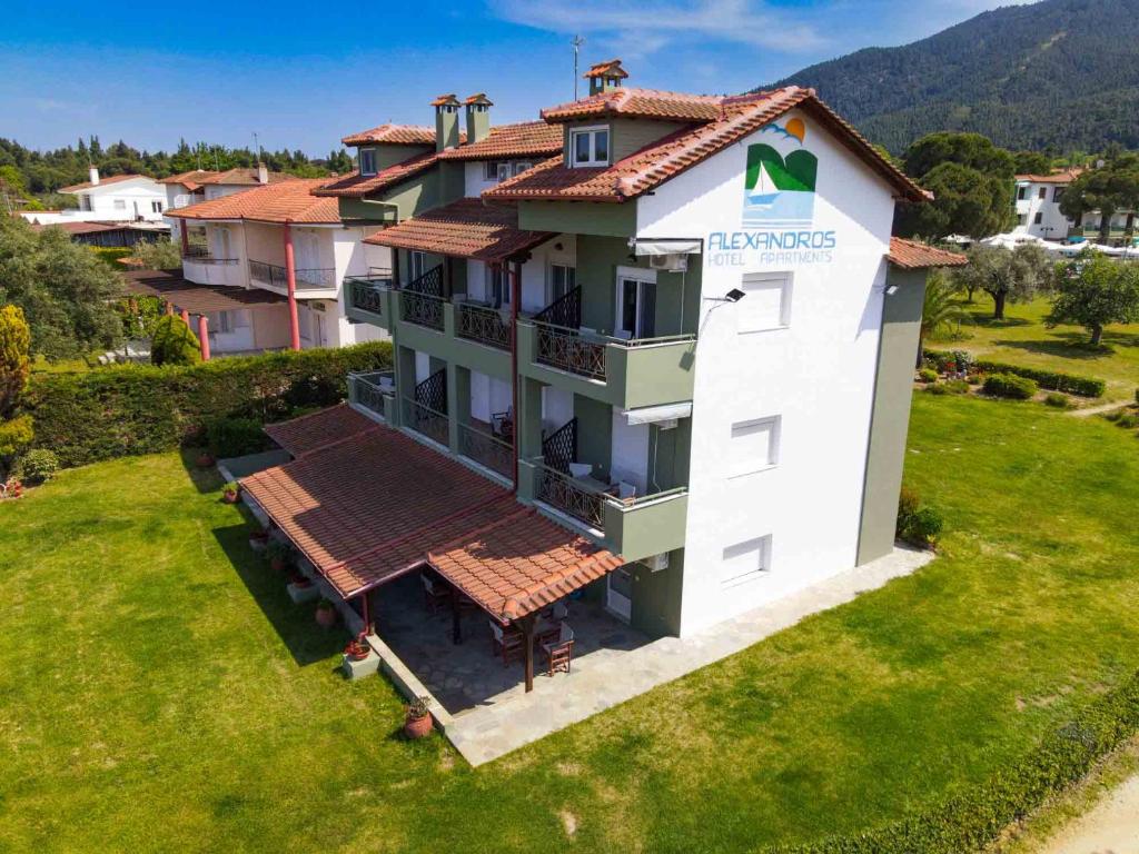 una vista aérea de un edificio con un cartel en él en Alexandros Hotel Apartments, en Vourvourou