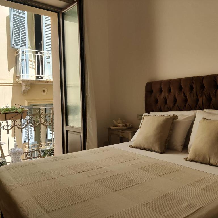 a bedroom with a large bed with a large window at Carlo's rooms in Trapani