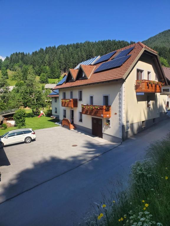 uma casa com painéis solares no telhado em Apartma Lip em Rateče
