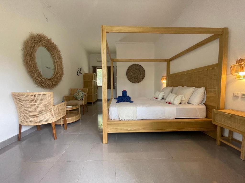 a bedroom with a large bed with a large mirror at Blue EmOcean resort in Moyo Island