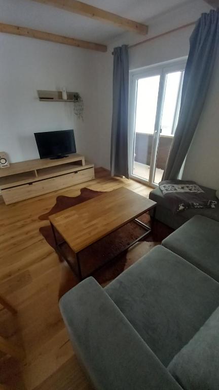 a living room with a wooden table and a window at Haus Stille Oase in Bruck an der Großglocknerstraße