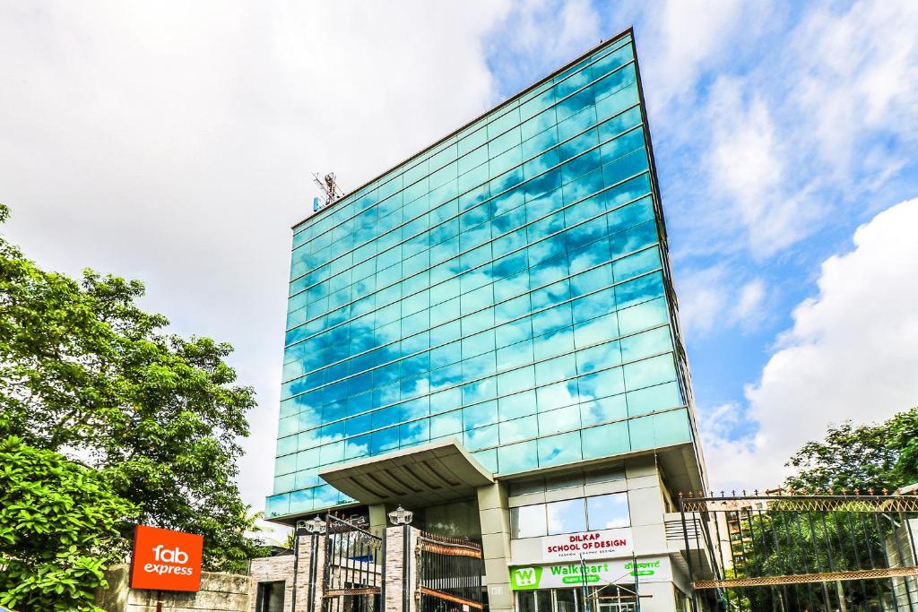 un edificio de cristal alto con una persona encima en FabExpress Ascot International Andheri East en Bombay
