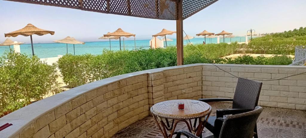 une terrasse avec une table et des chaises et la plage dans l'établissement شاليه براس سدر اطلاله بحر, à Ras Sudr