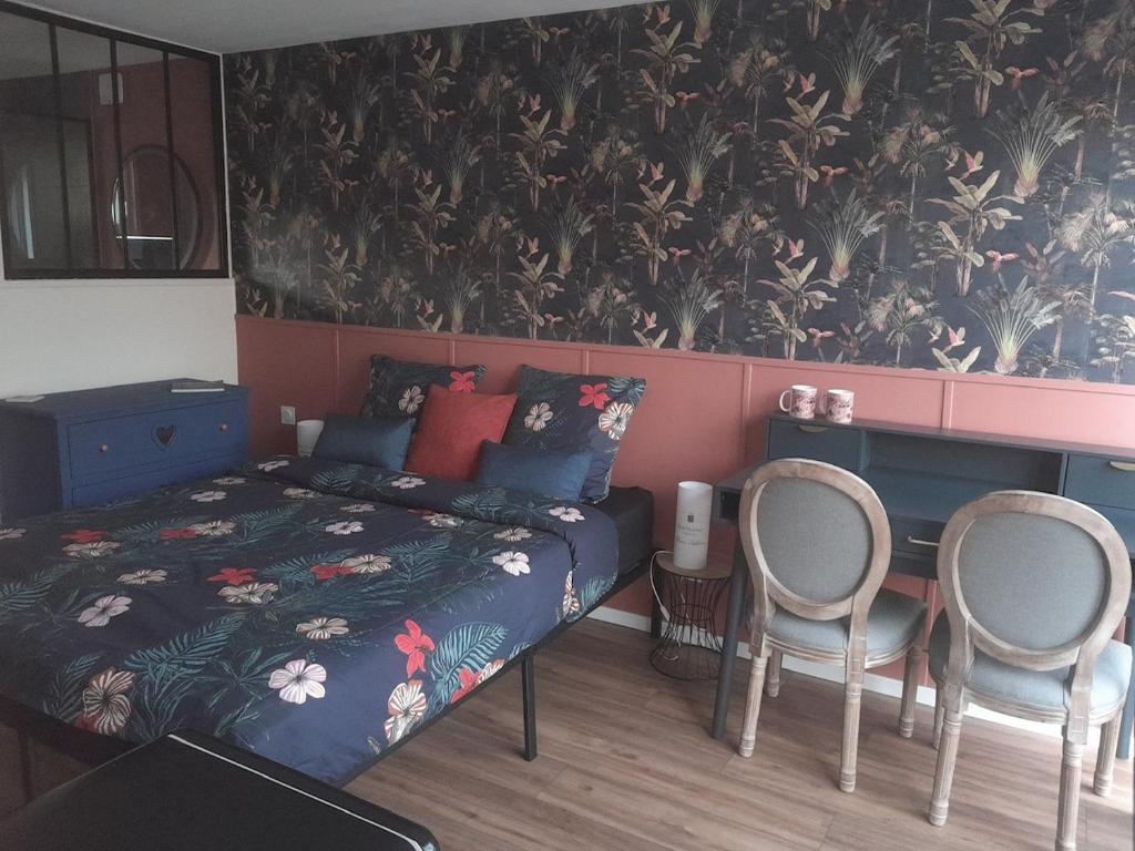 een slaapkamer met een bed en 2 stoelen bij Suite des Grands Crus in Beaune