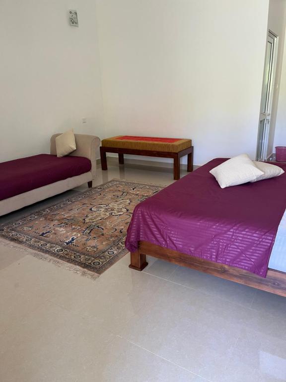 sala de estar con 2 camas y alfombra en Nature Resort en Polonnaruwa