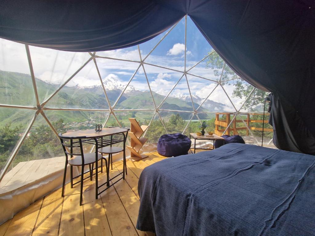 a room with a bed and a table in a tent at Elia Glamping in Stepantsminda