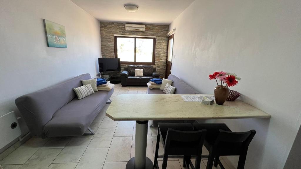 a living room with a table and a couch at Elena Court Apartments in Ayia Napa
