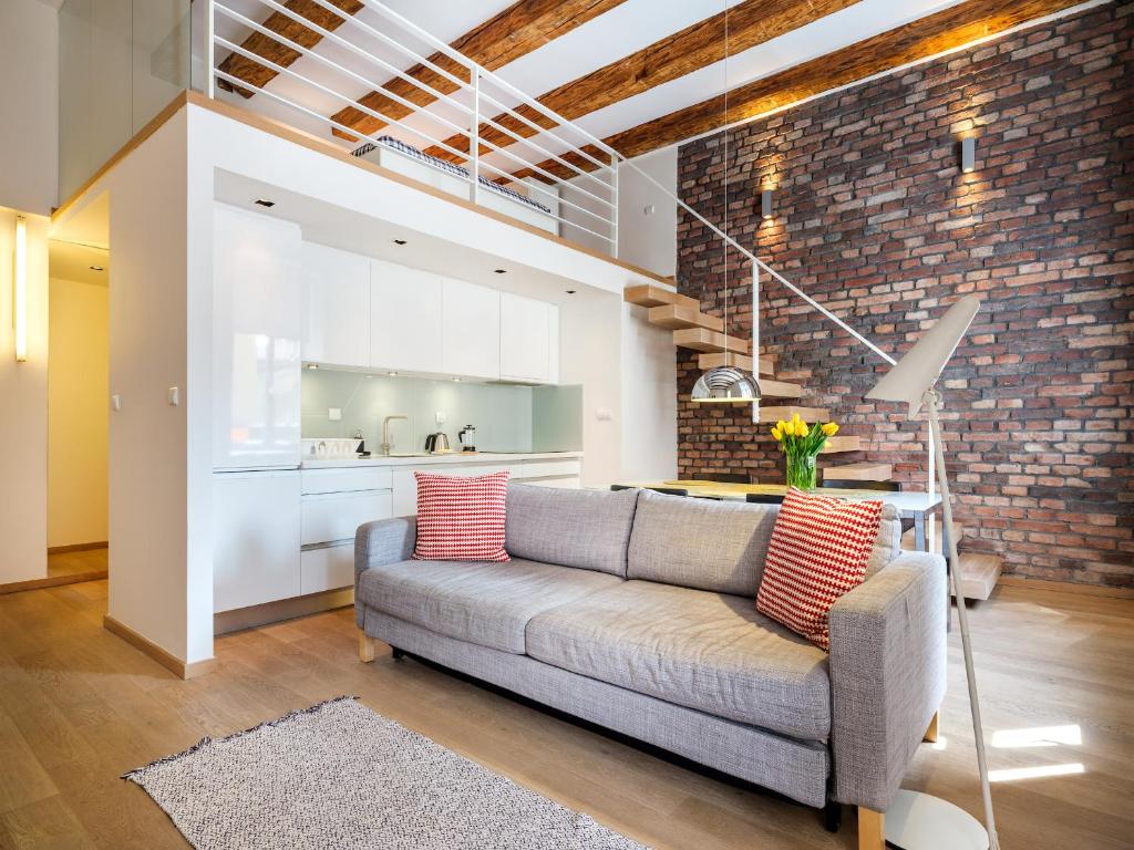 a living room with a couch and a brick wall at Tyzenhauz Apartments Comfort in Krakow