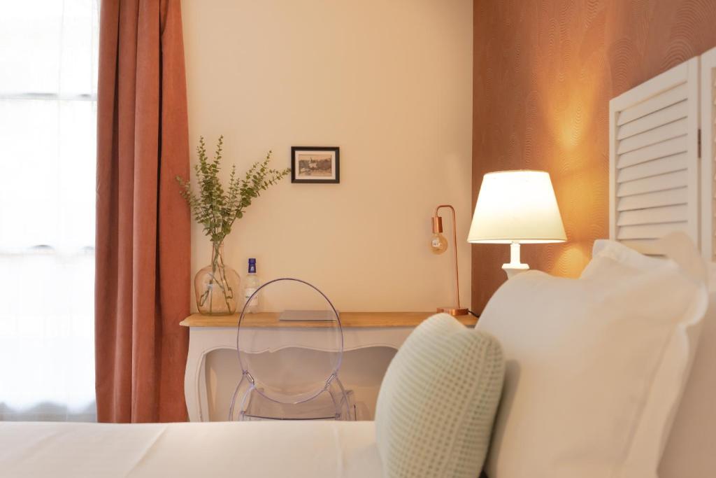 1 dormitorio con 1 cama y escritorio con silla en Hotel-Restaurant des Augustins - Cosy Places by CC - Proche Sarlat, en Saint-Cyprien