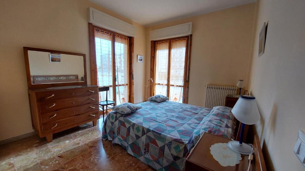 Schlafzimmer mit einem Bett, einer Kommode und Fenstern in der Unterkunft AlbengaMare in Albenga