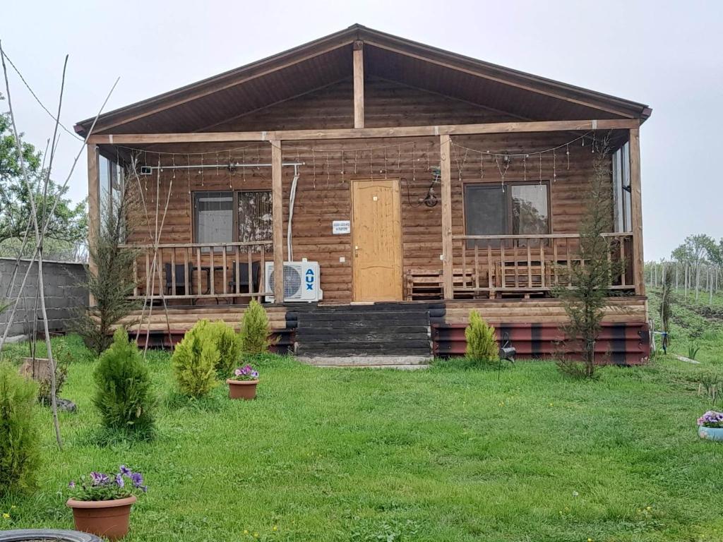 a log cabin with a porch and a door at Wooden House Ashuri in Veltaurtkari