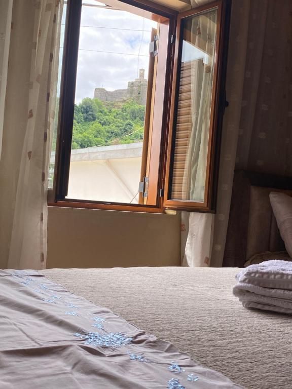 a bedroom with a bed and a window with a view at Marko's House in Gjirokastër