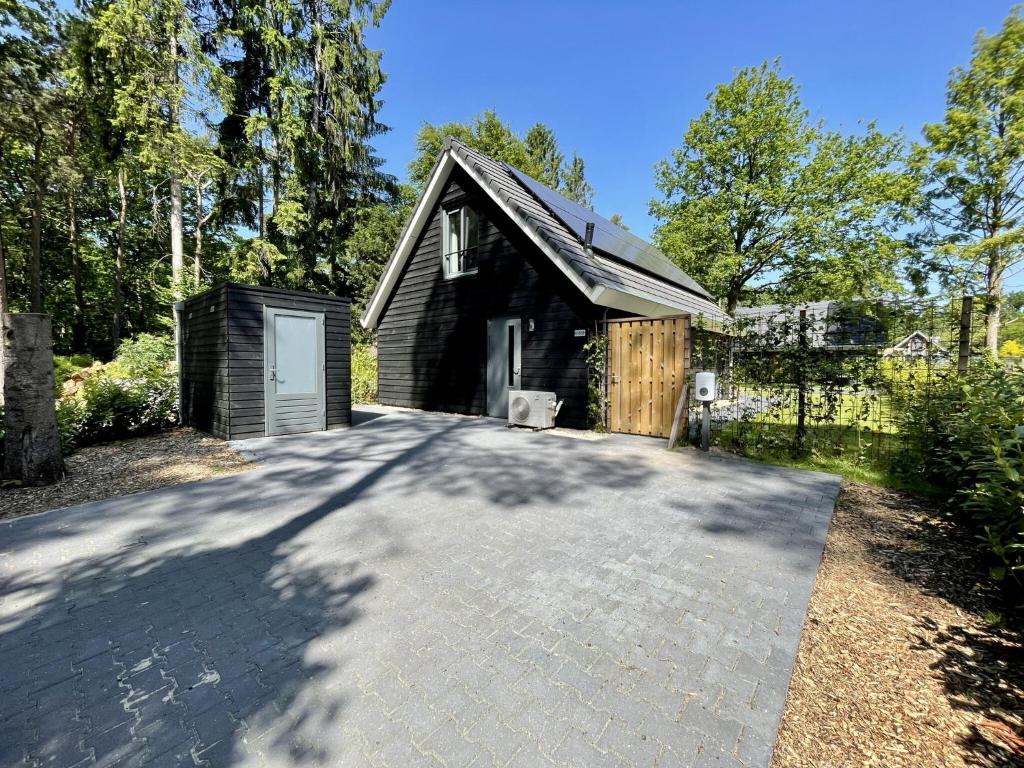 una casa con garage e vialetto di Cosy energy friendly holiday home in a wooded area in Lochem a Lochem