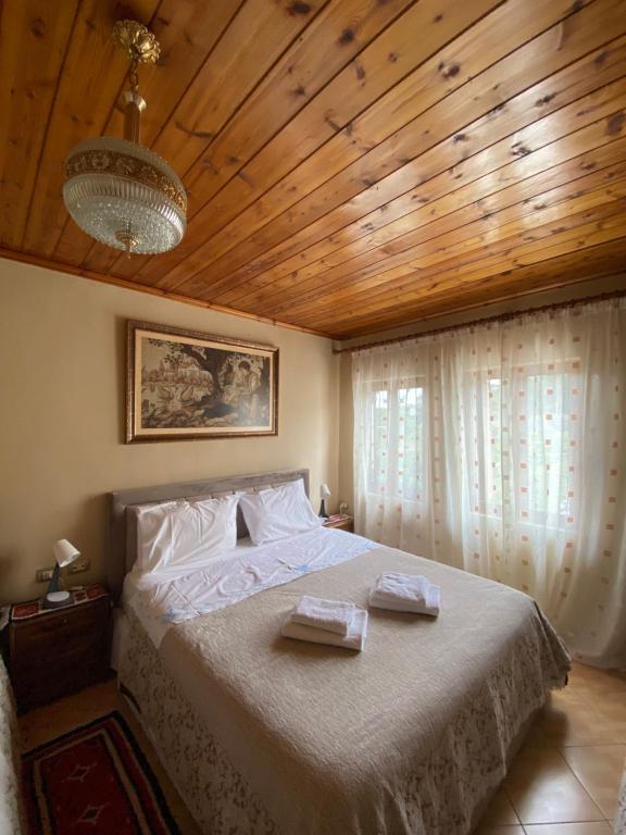 a bedroom with a large bed with a wooden ceiling at Marko's House in Gjirokastër