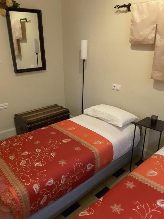 a small room with a bed and a mirror at EN EL CORAZÓN DE HUESCA in Huesca