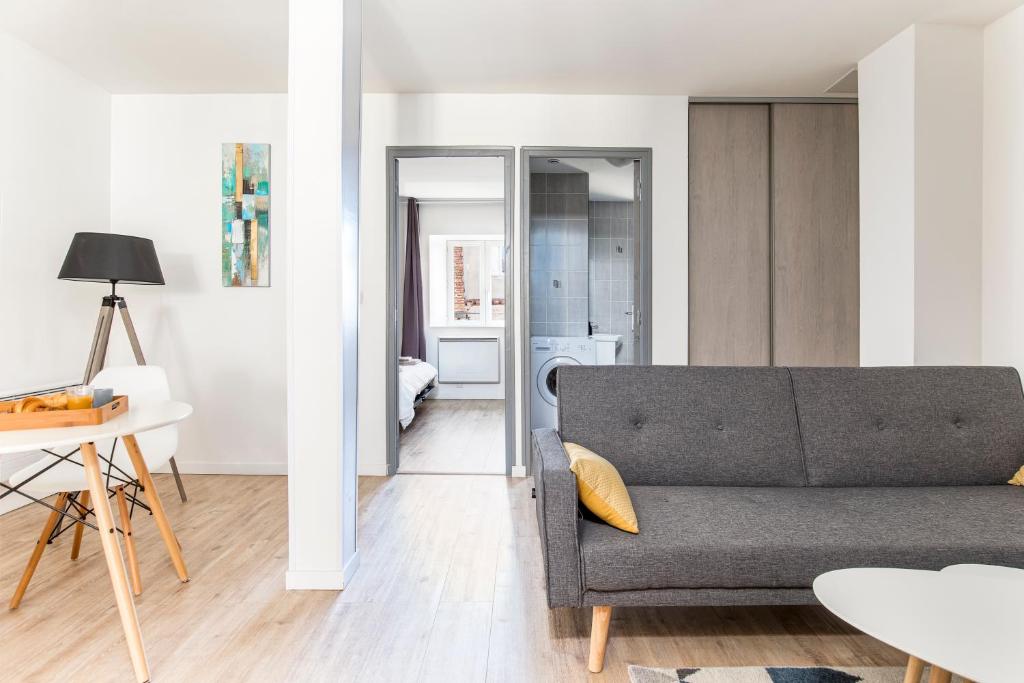 un salon avec un canapé et une table dans l'établissement WhiteHorse 2 CahorsCityStay, à Cahors