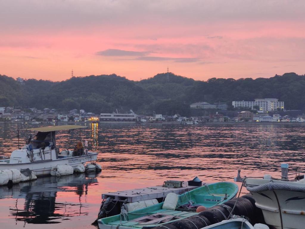 a group of boats docked in the water at sunset at Guesthouse SETOUCHI LIFE in Kure