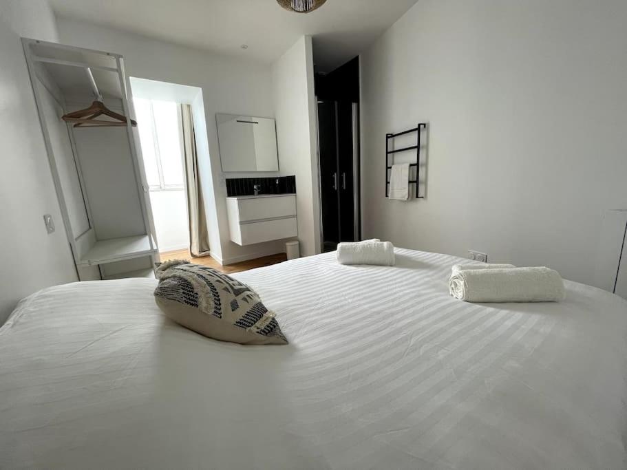 uma grande cama branca com duas almofadas em Les Suites Paloises - Appt. 4 : Le Parc Beaumont em Pau