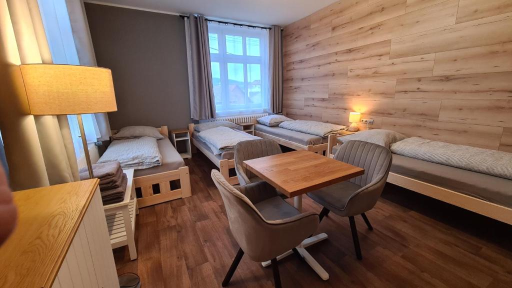 una habitación con mesa y sillas y una habitación con camas en Penzion Pod Zámkem, en Vizovice