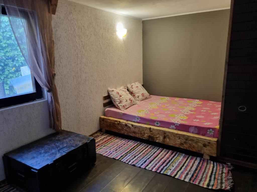 een kleine kamer met een bed en een raam bij Magic Garden Bungalow in Vama Veche