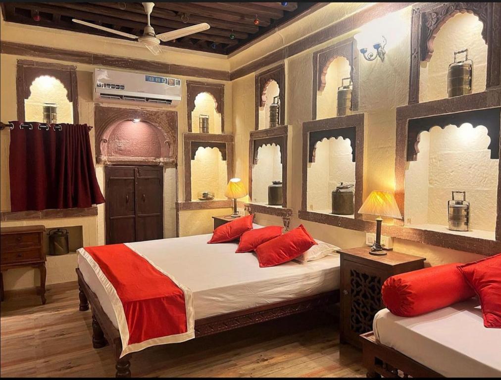 a bedroom with two beds with red pillows and windows at Juna Mahal Boutique Home Stay in Jodhpur