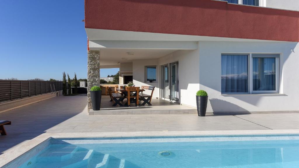 uma casa com piscina em frente a uma casa em Luxury residence Villa Astria em Knežević