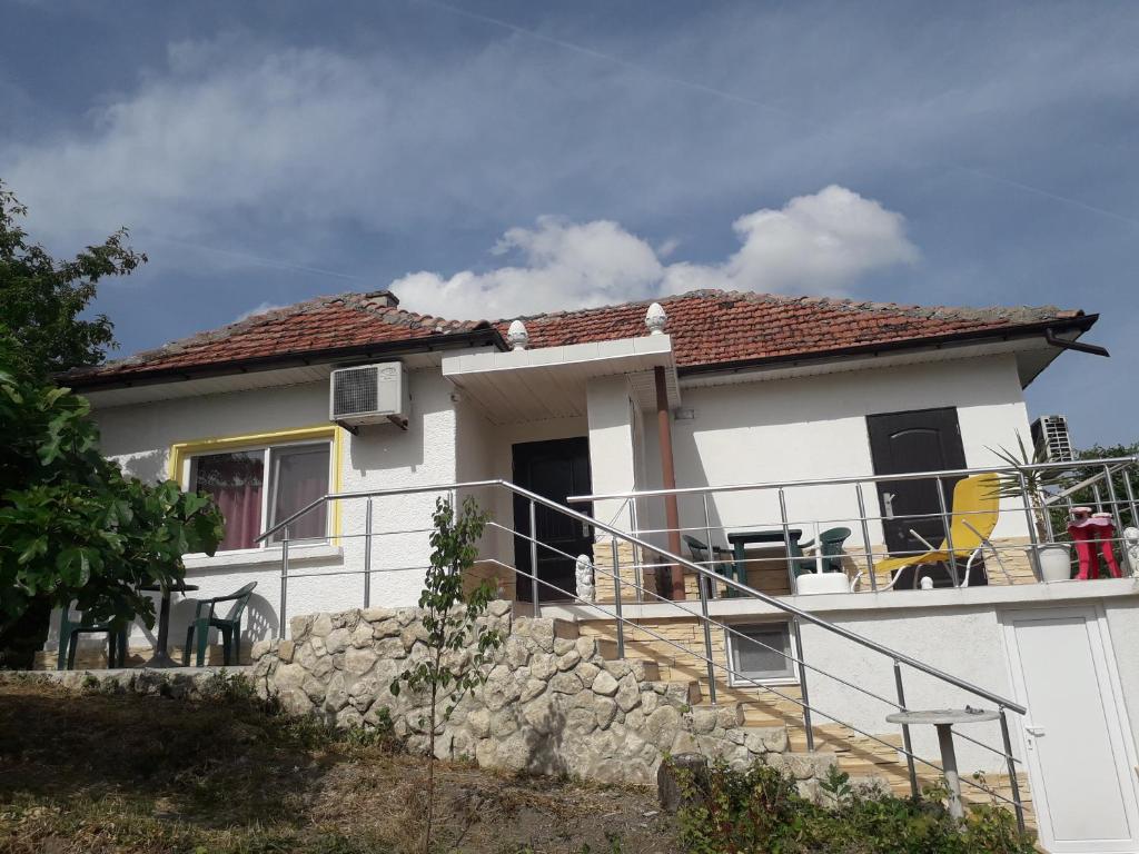 a small white house with a stone wall at LenNy 2 in Kranevo