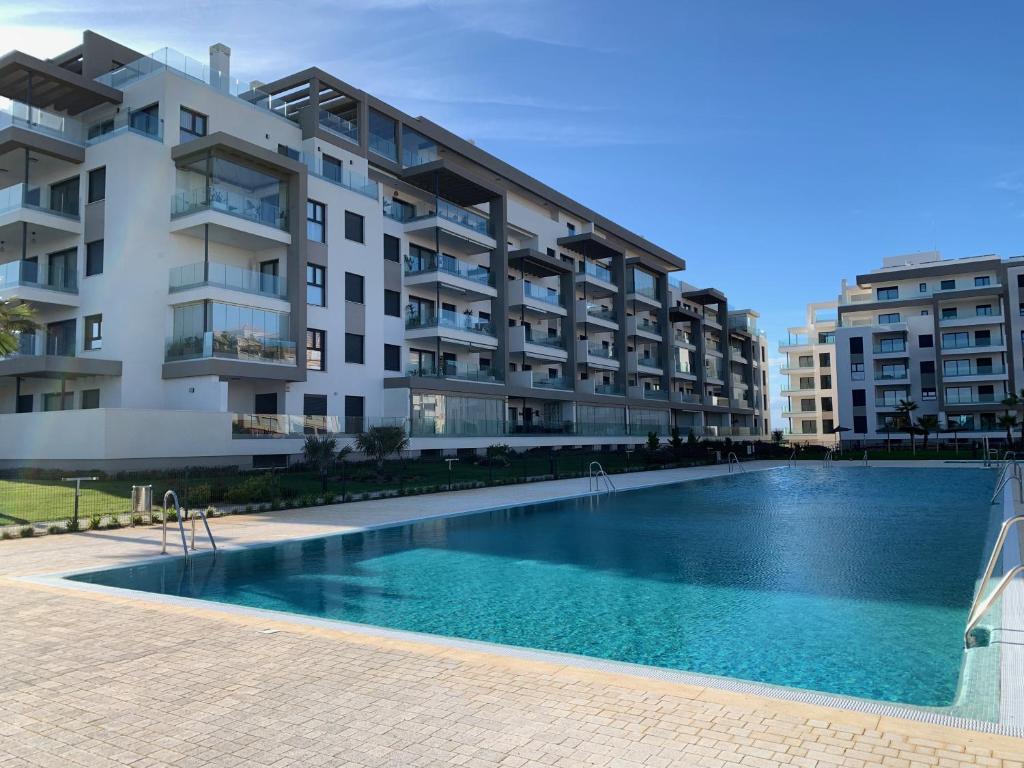 basen przed budynkiem w obiekcie Penthouse with wide terrace next to the ocean w mieście Huelva