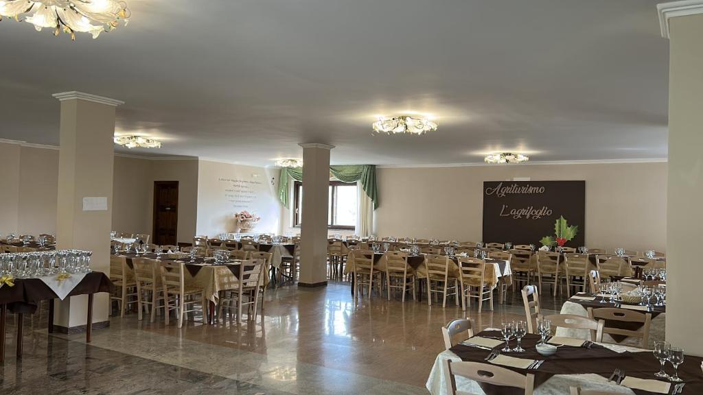 una sala de banquetes con mesas y sillas y una pizarra en L’agrifoglio en Francavilla in Sinni