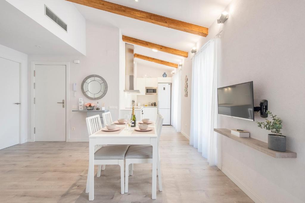ein weißes Esszimmer mit einem weißen Tisch und Stühlen in der Unterkunft Lovely and bright apartment in the heart of Banyoles in Banyoles