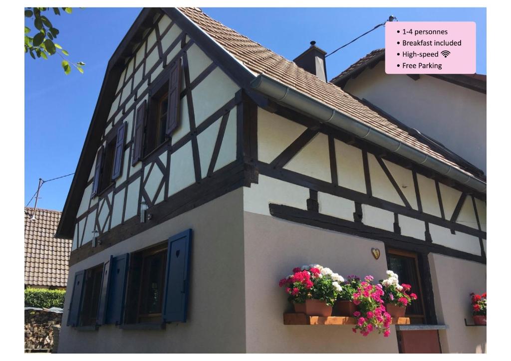 una casa blanca con flores en la ventana en Maison de la Sauer - Bed and Breakfast | Chambre d’hôtes | Ferienhaus en Munchhausen