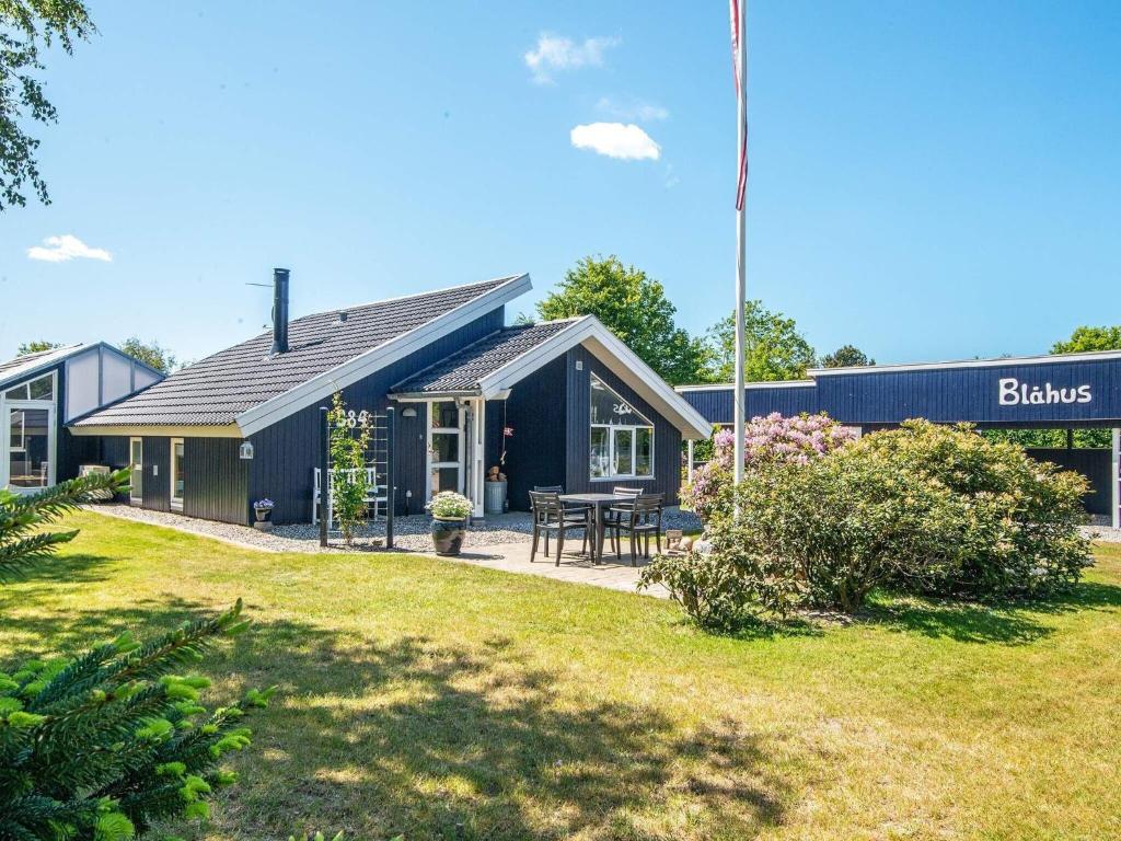 Vangにある6 person holiday home in Ulfborgの庭のピクニックテーブル付黒家